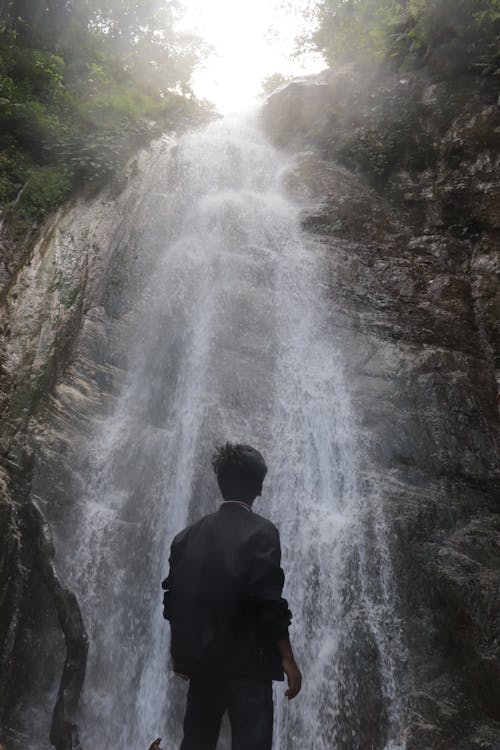 Man Standing Near Waterfalls