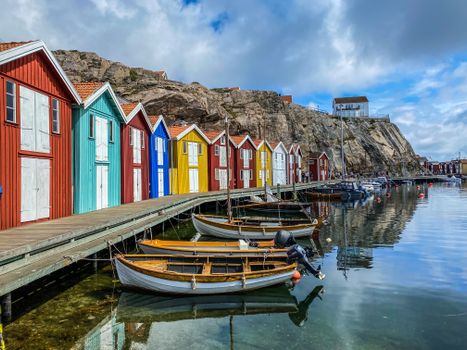Boats Moored and Multicolour Sheds on a Rocky Coast