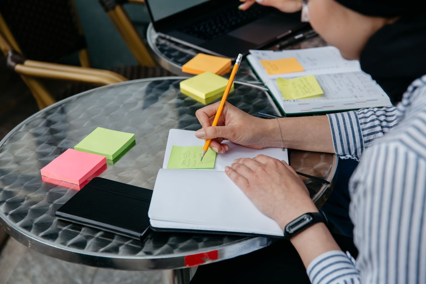 Hands arranging sticky notes at a table
