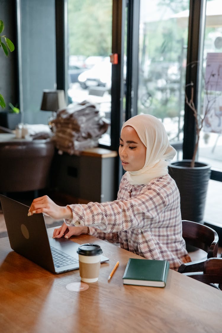 A Woman Sitting At The Wooden Table