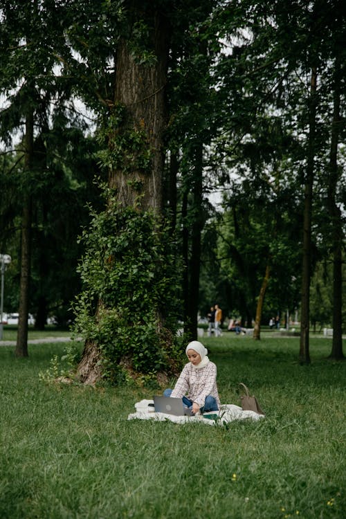 Woman Using a Laptop while at a Park