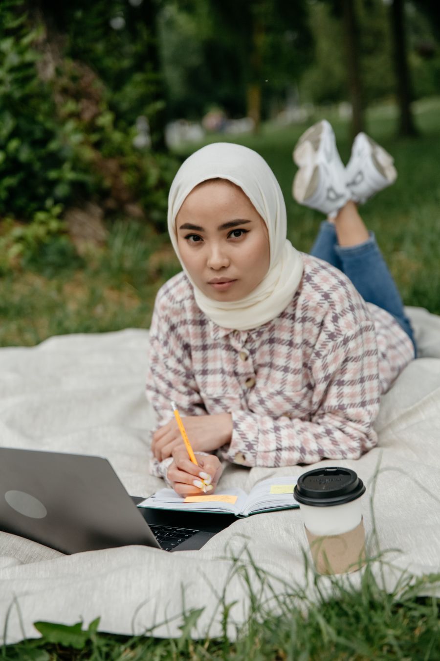 Peserta berhijab belajar TOEFL secara daring dari taman