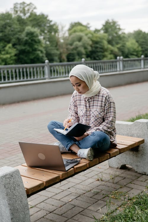 Woman Working with Laptop on City Street