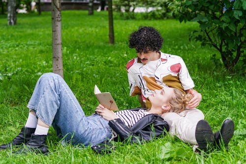 Free Photo of a Woman in a Leather Jacket Lying on a Man's Lap Stock Photo