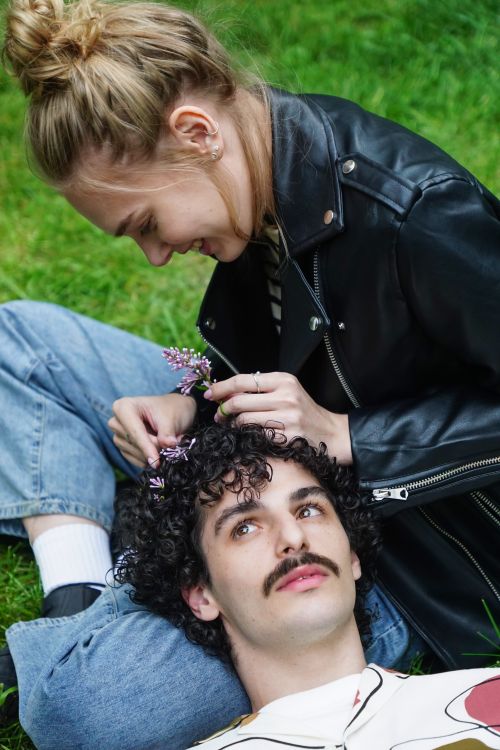 Free A couple enjoying a playful moment outdoors with flowers, showcasing romance and joy. Stock Photo