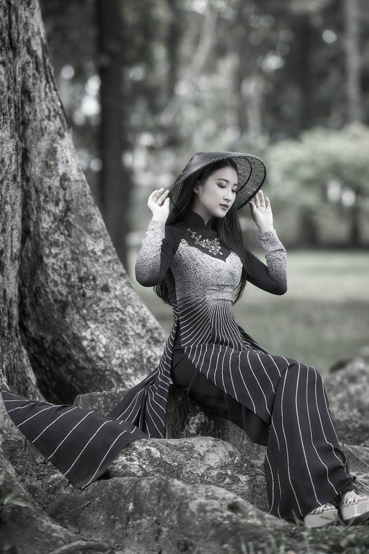 Black And White Photo Of A Woman Sitting On A Tree Root