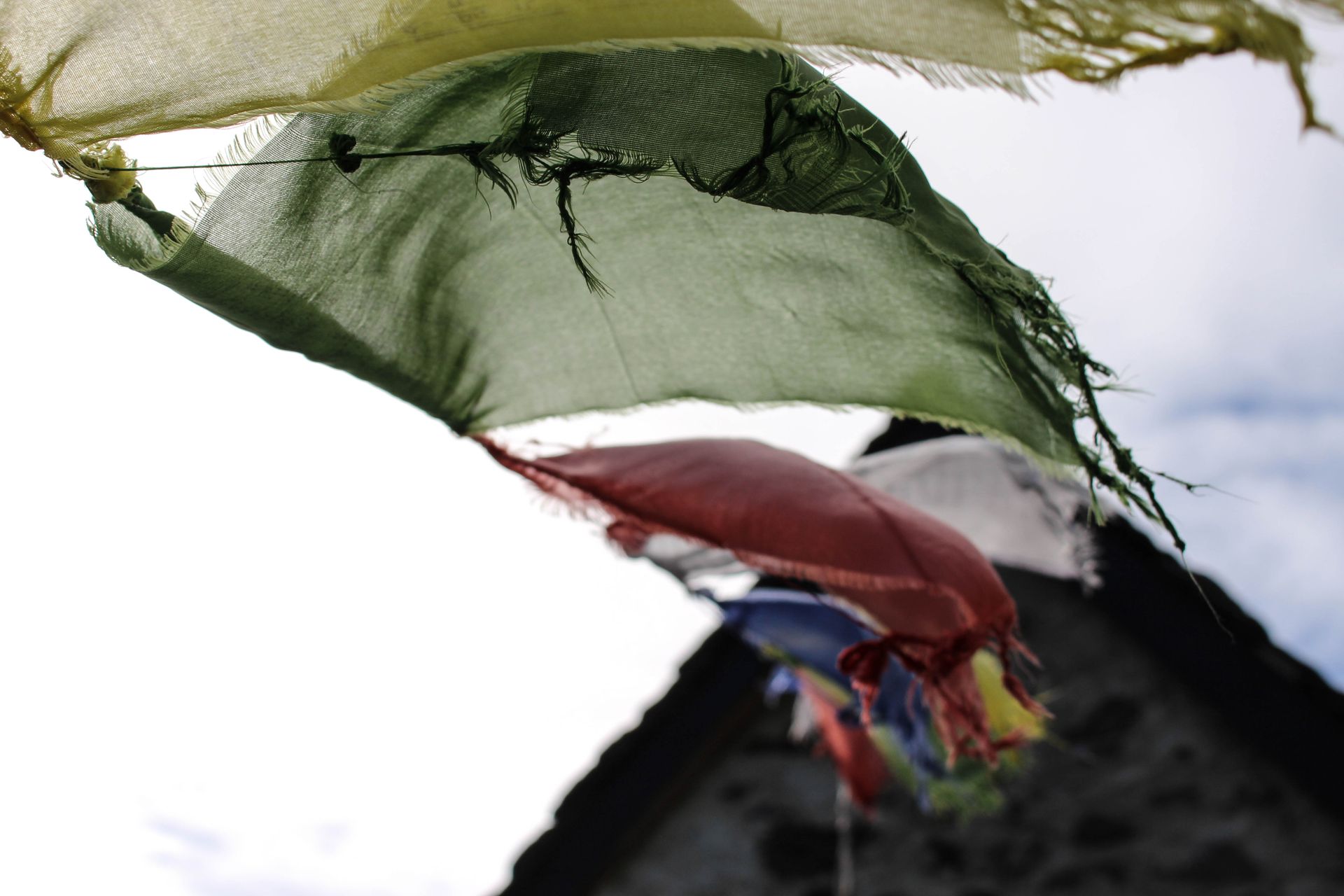 Colorful prayer flags fluttering with a clear blue sky background, capturing cultural essence.