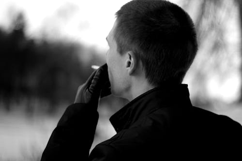 Grayscale Photo of a Man Smoking