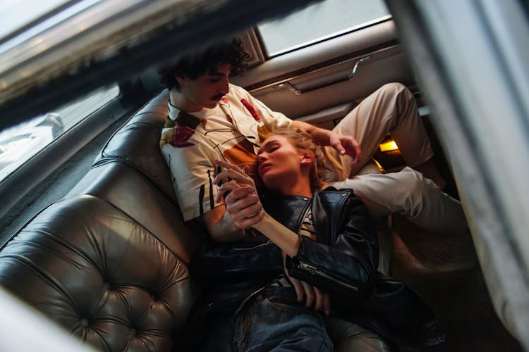 Photo Of Woman Lying On The Lap Of A Man Inside The Car