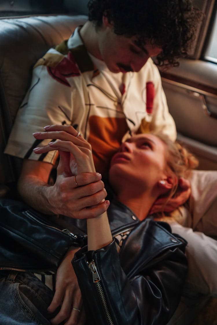 Woman In Leather Jacket Lying On The Lap Of A Man