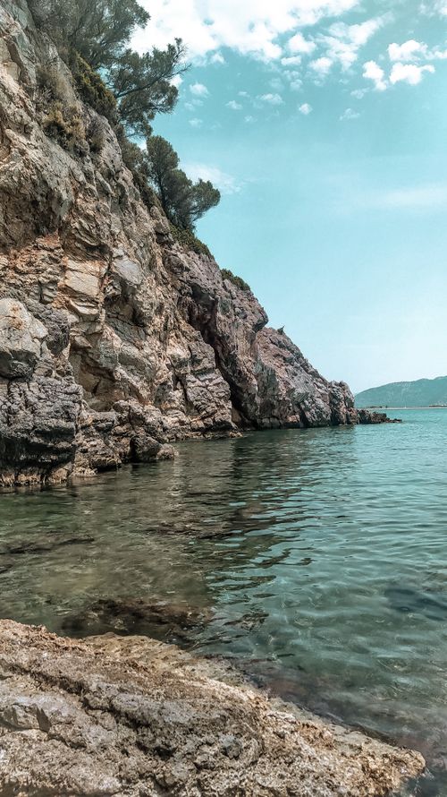 Free Beautiful cliffside view with clear blue sea under a bright sky perfect for nature enthusiasts. Stock Photo