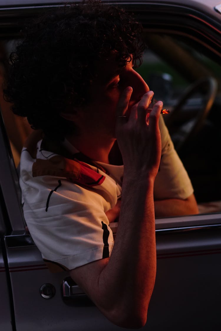 A Curly-Haired Man Smoking Cigarette