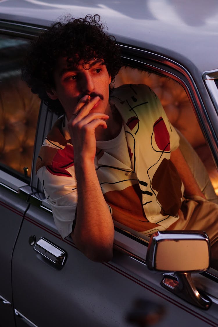 A Curly-Haired Man Smoking Cigarette