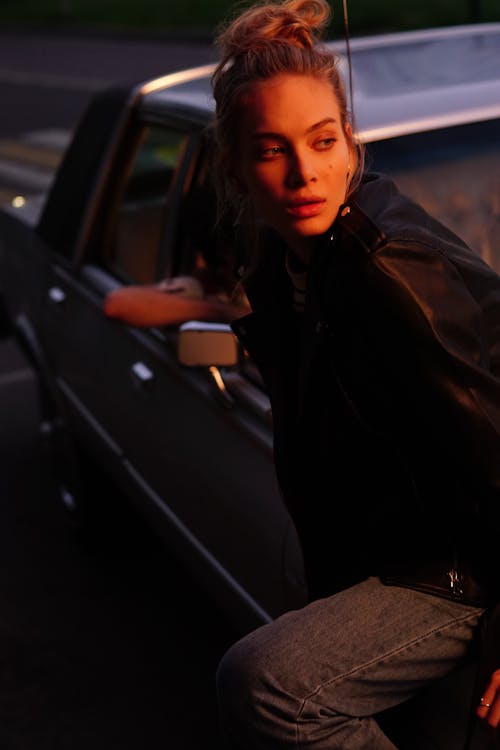 Woman Sitting on a Car's Hood