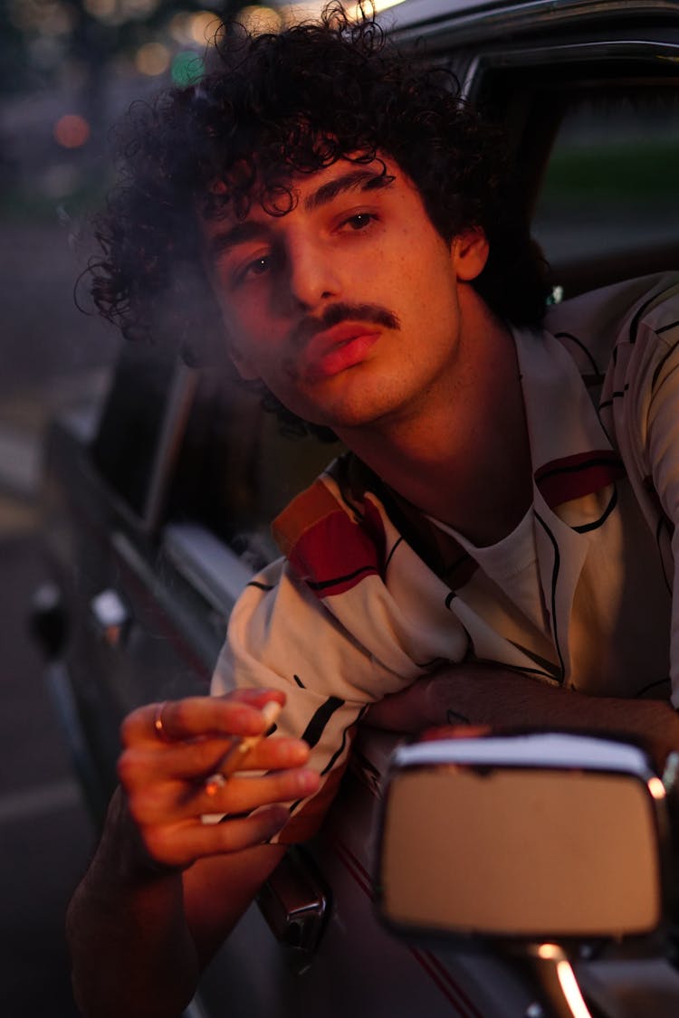 A Curly-Haired Man Smoking Cigarette