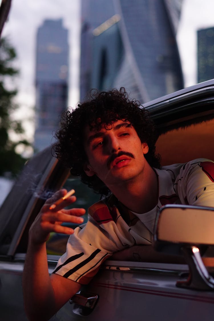 Man In Brown Button Up Shirt Sitting In A Car