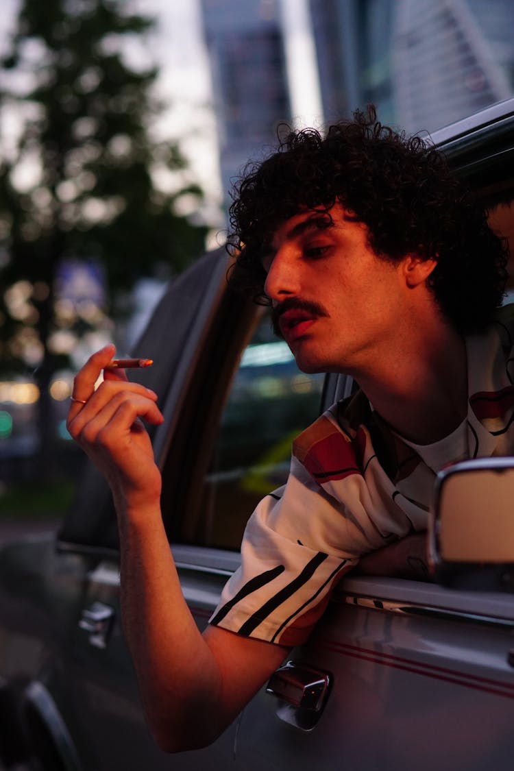 A Curly-Haired Man Smoking Cigarette