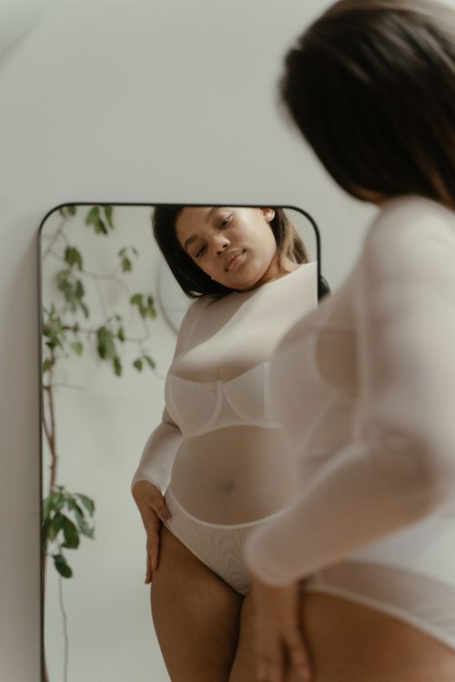Free A woman embraces self-love and body positivity in a reflective mirror portrait. Stock Photo