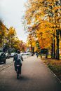 Man in Black Jacket and Black Pants Walking on Sidewalk
