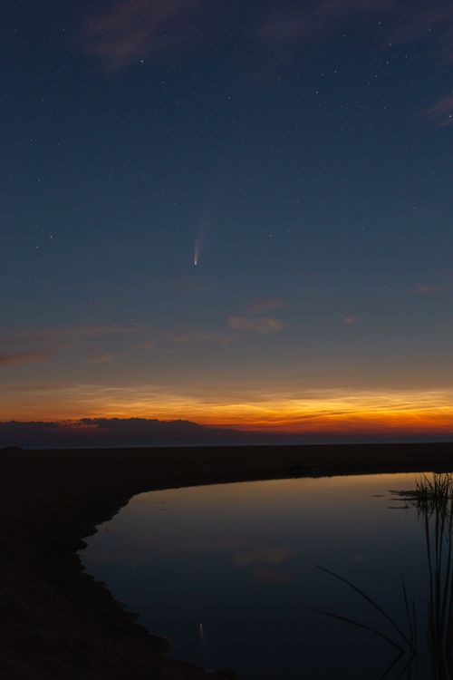 Free Beautiful twilight scene with comet, stars, and reflection over calm lake. Stock Photo