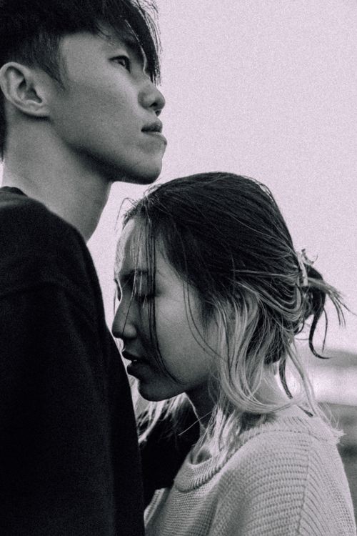 Free A close and thoughtful couple captured in a black-and-white vertical shot. Stock Photo