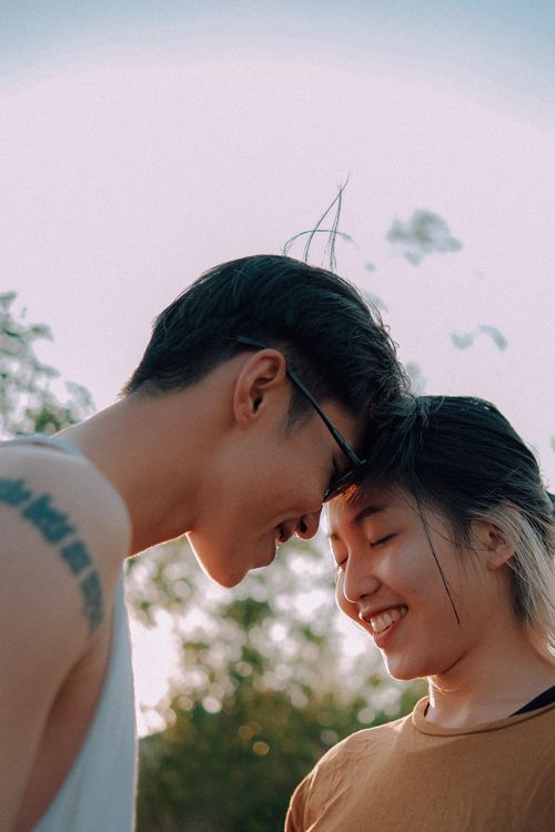 Free A happy couple shares a tender moment outdoors under a clear sky. Stock Photo