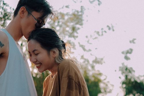 Free A loving couple outdoors sharing an intimate and joyful moment under soft light. Stock Photo