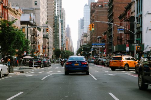 Free A lively city street bustling with traffic and towering skyscrapers. Stock Photo