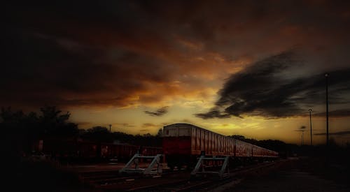 無料 日没時に撮影した赤と白の電車 写真素材