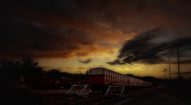 Serene train silhouette with vibrant sunset sky and dramatic clouds.