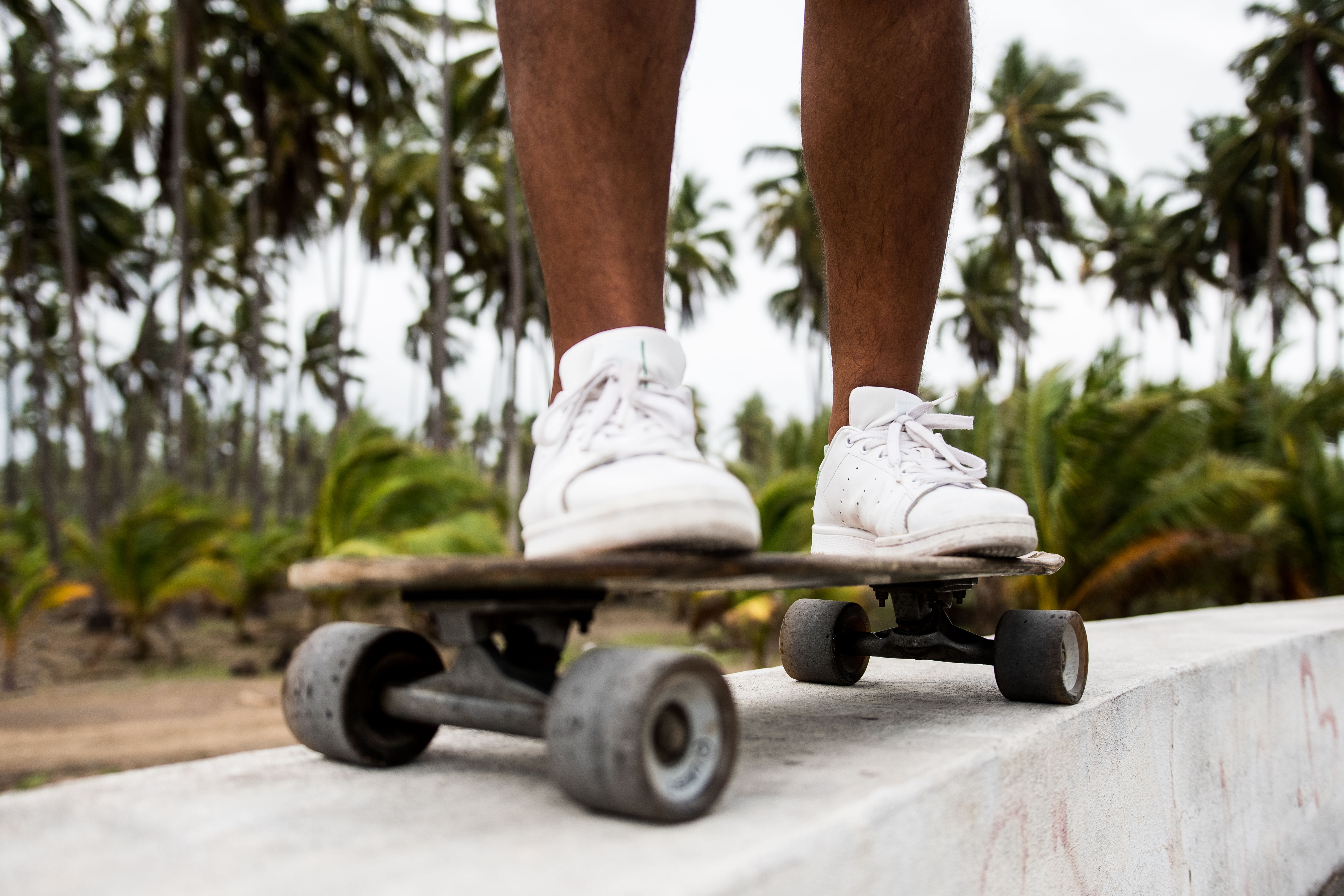 Person in White Sneakers Riding Longboard · Free Stock Photo