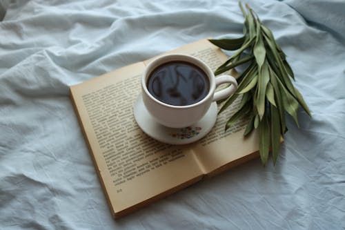 Photo of a Cup of Coffee on Top of an Open Book