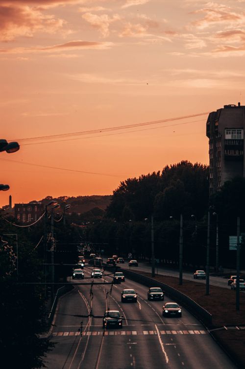 Free View of cars on a Kaliningrad road during sunset with warm tones and urban scenery. Stock Photo