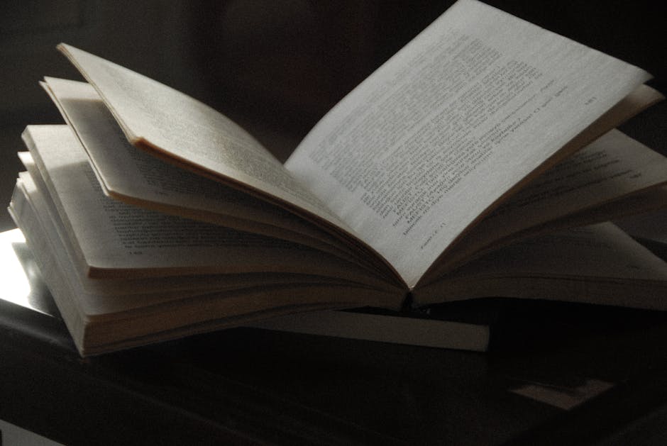 A close-up of an open book with visible text, placed on a dark wooden surface. Ideal for reading-themed content.