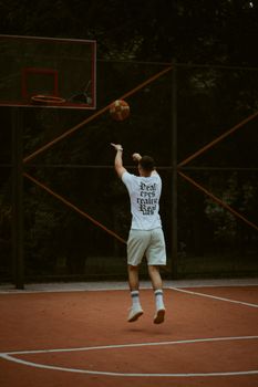 Athlete taking a jump shot on an outdoor basketball court in Chișinău, Moldova.
