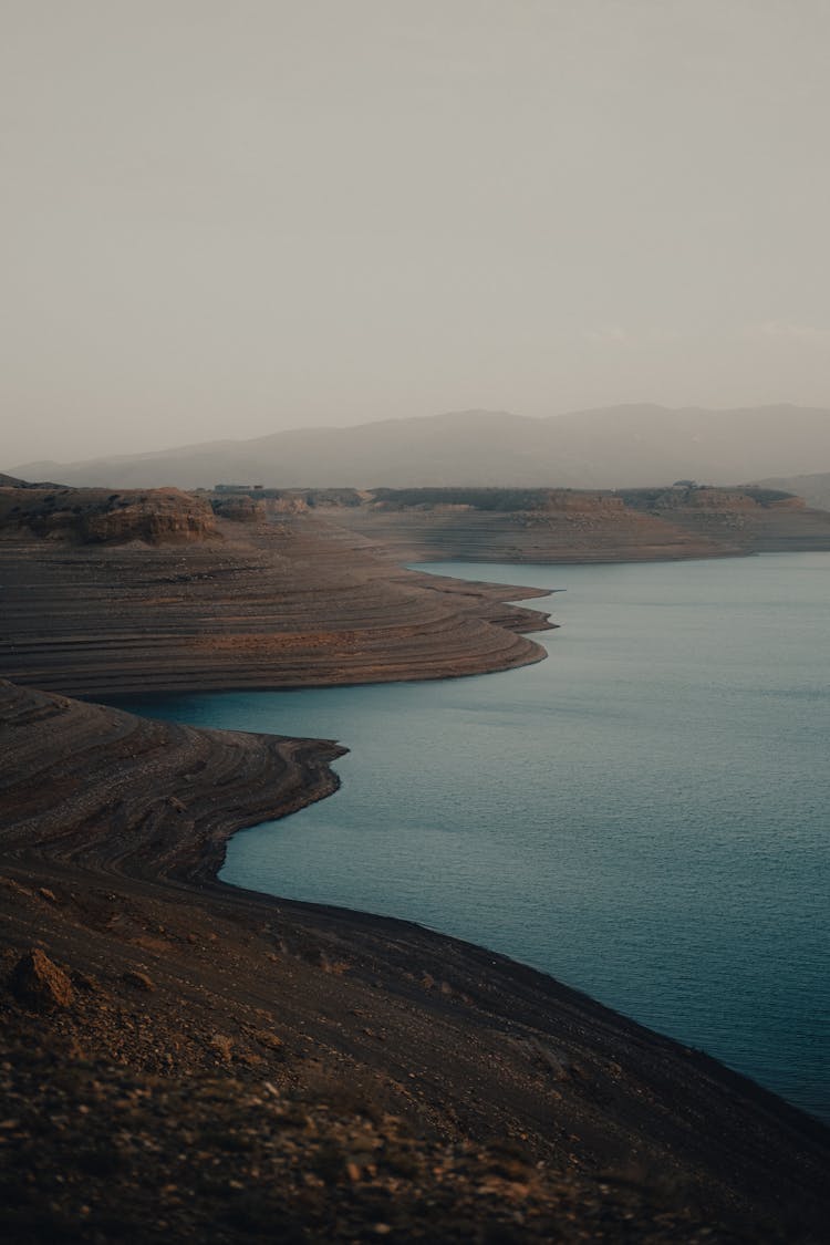 Barren Hills And Lake On A Misty Day 