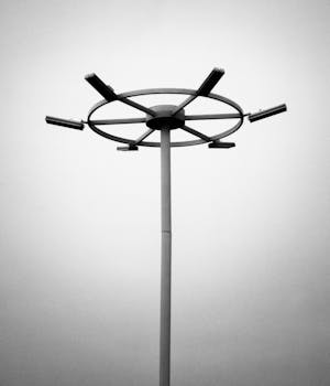Black and white image of a contemporary light mast set against an overcast sky.