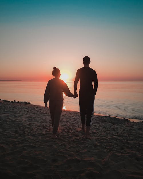 Silhouette of a Couple Holding Hands at a Beach