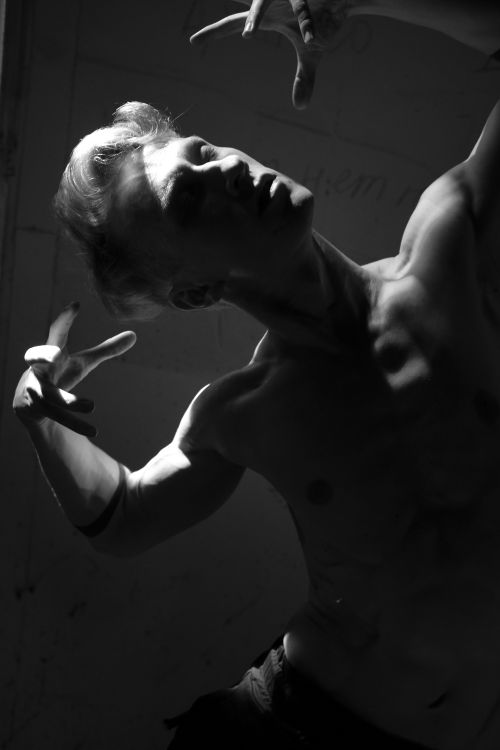 Free Striking black and white portrait of a shirtless man posing dramatically in low light. Stock Photo