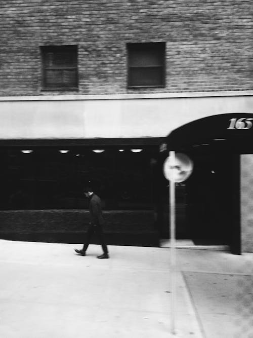 Grayscale Photo of a Man Walking