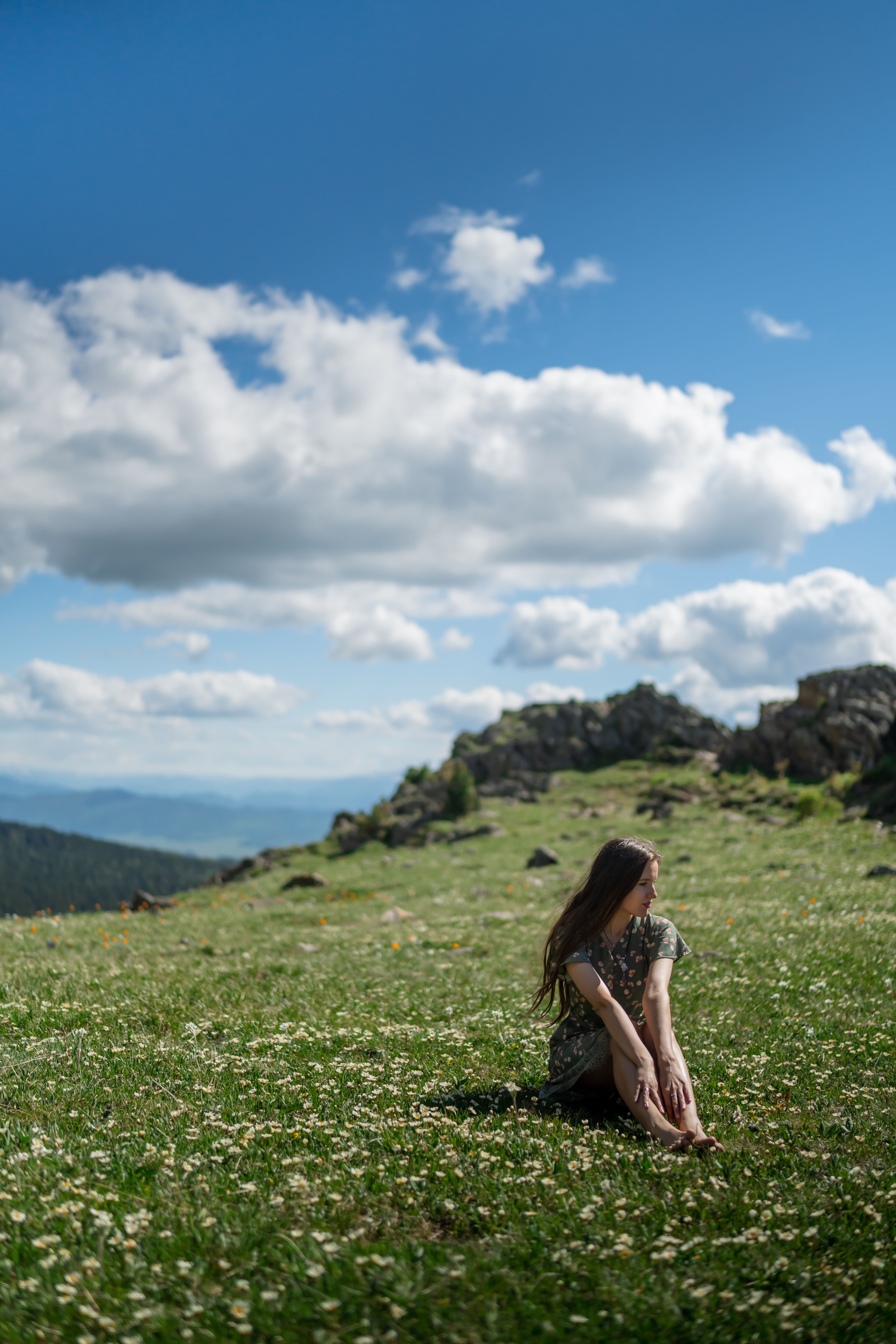 A Woman in Dress Sitting on Green Grass Field · Free Stock Photo