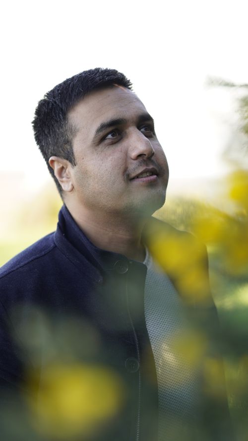 Free Close-up portrait of a man looking upwards surrounded by nature, evoking a reflective mood. Stock Photo