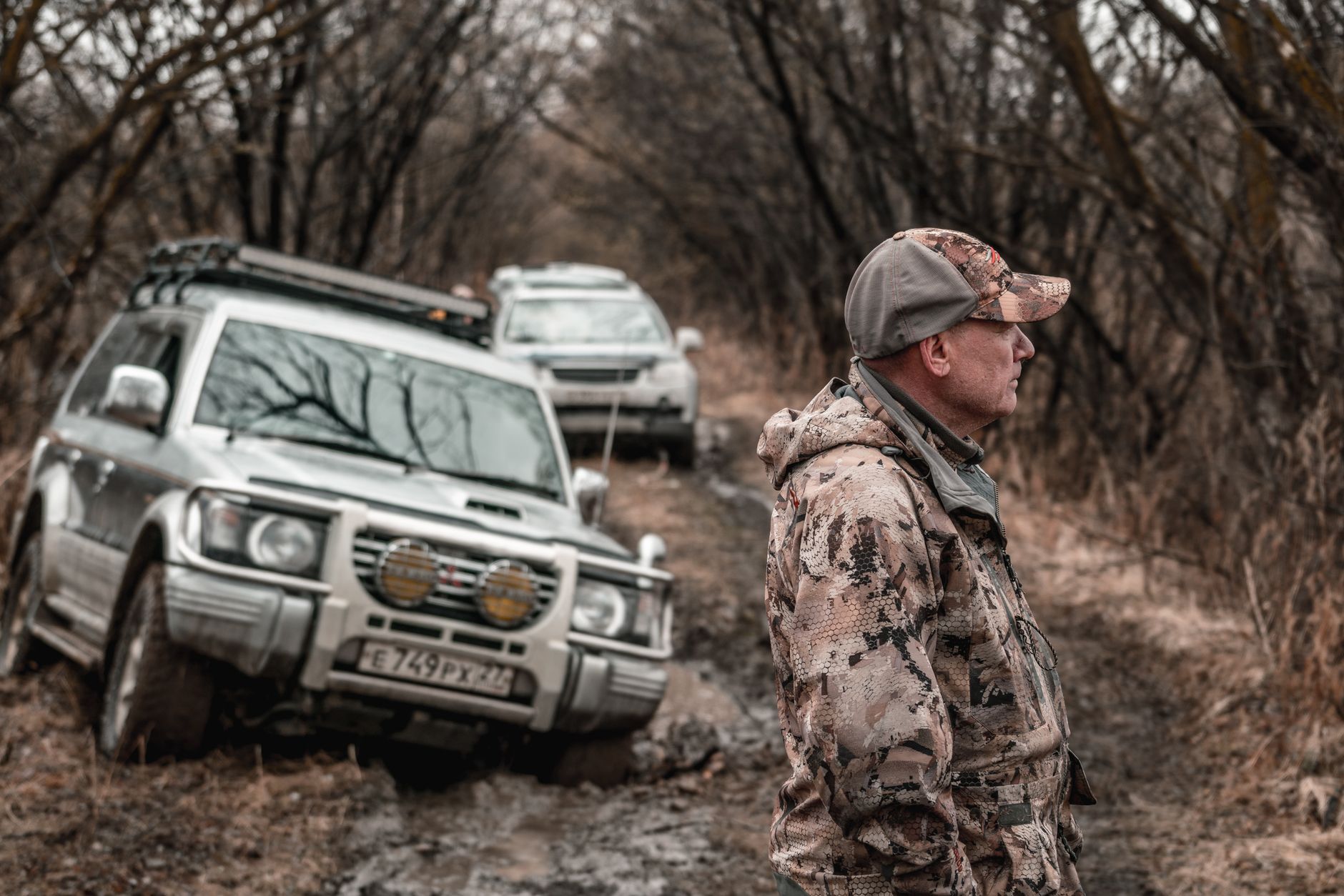 SUV navigating a deep rutted muddy forest trail where a solo driver could easily get stuck