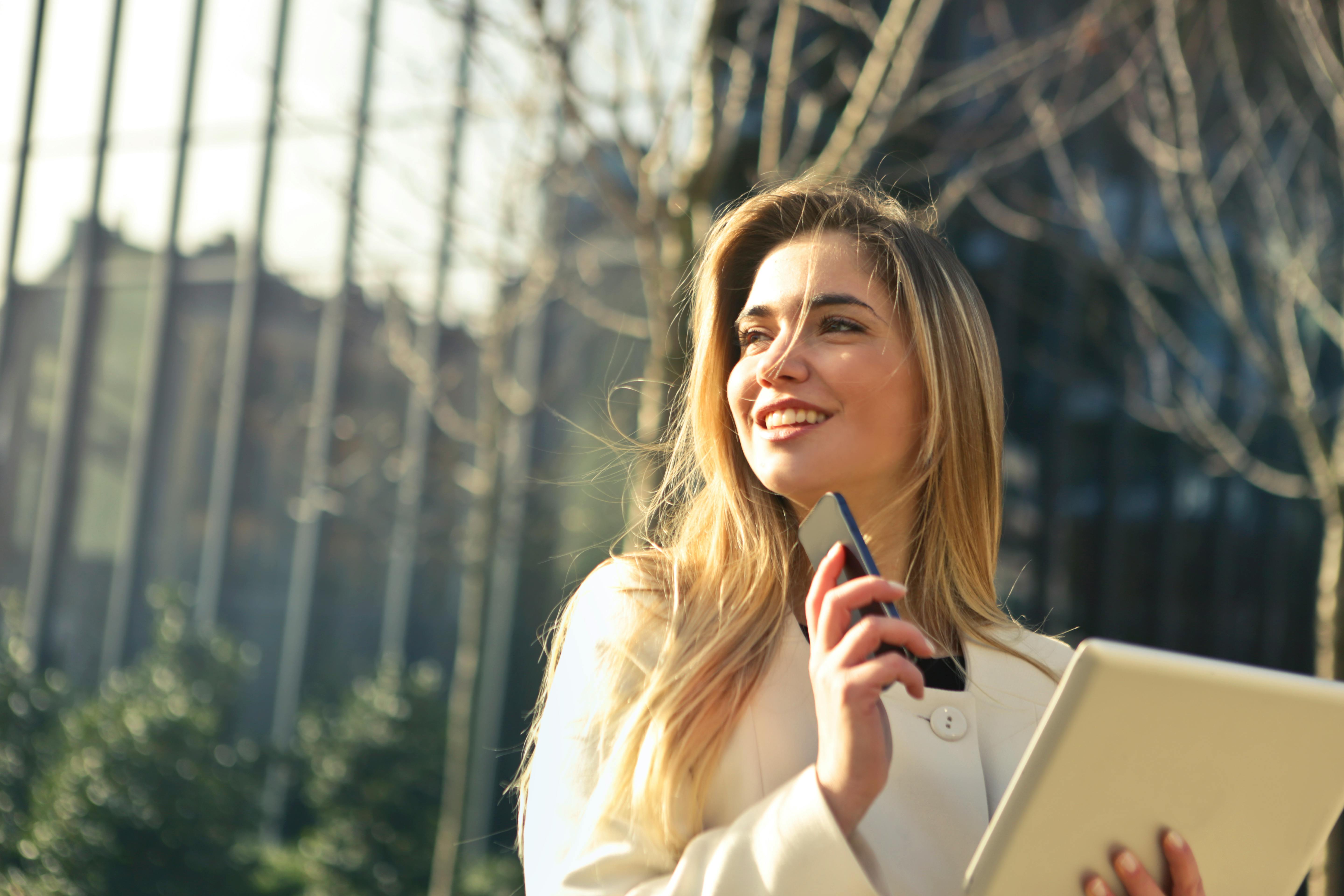 Woman holding a mobile phone and a tablet. | Photo: Pexels