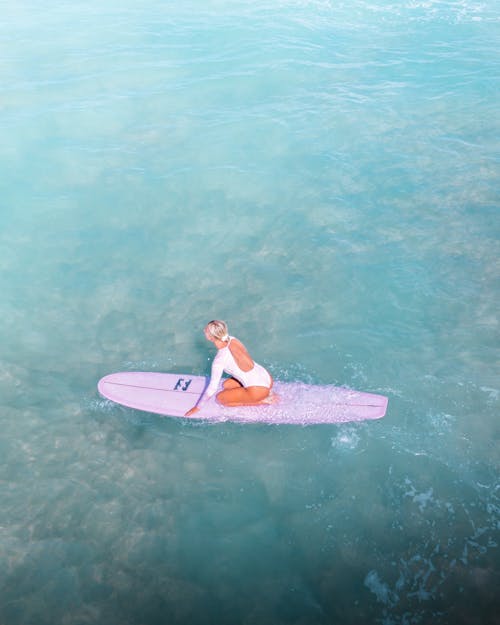 Free Woman Surfing in a Pink Surfboard Stock Photo