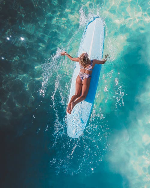 Woman in Floral Bikini on a Surfboard