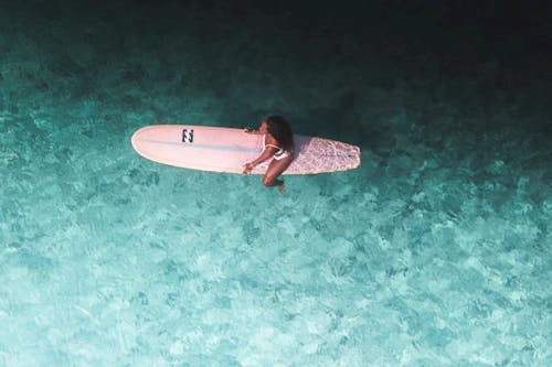 A Woman Sitting on a Surfboard