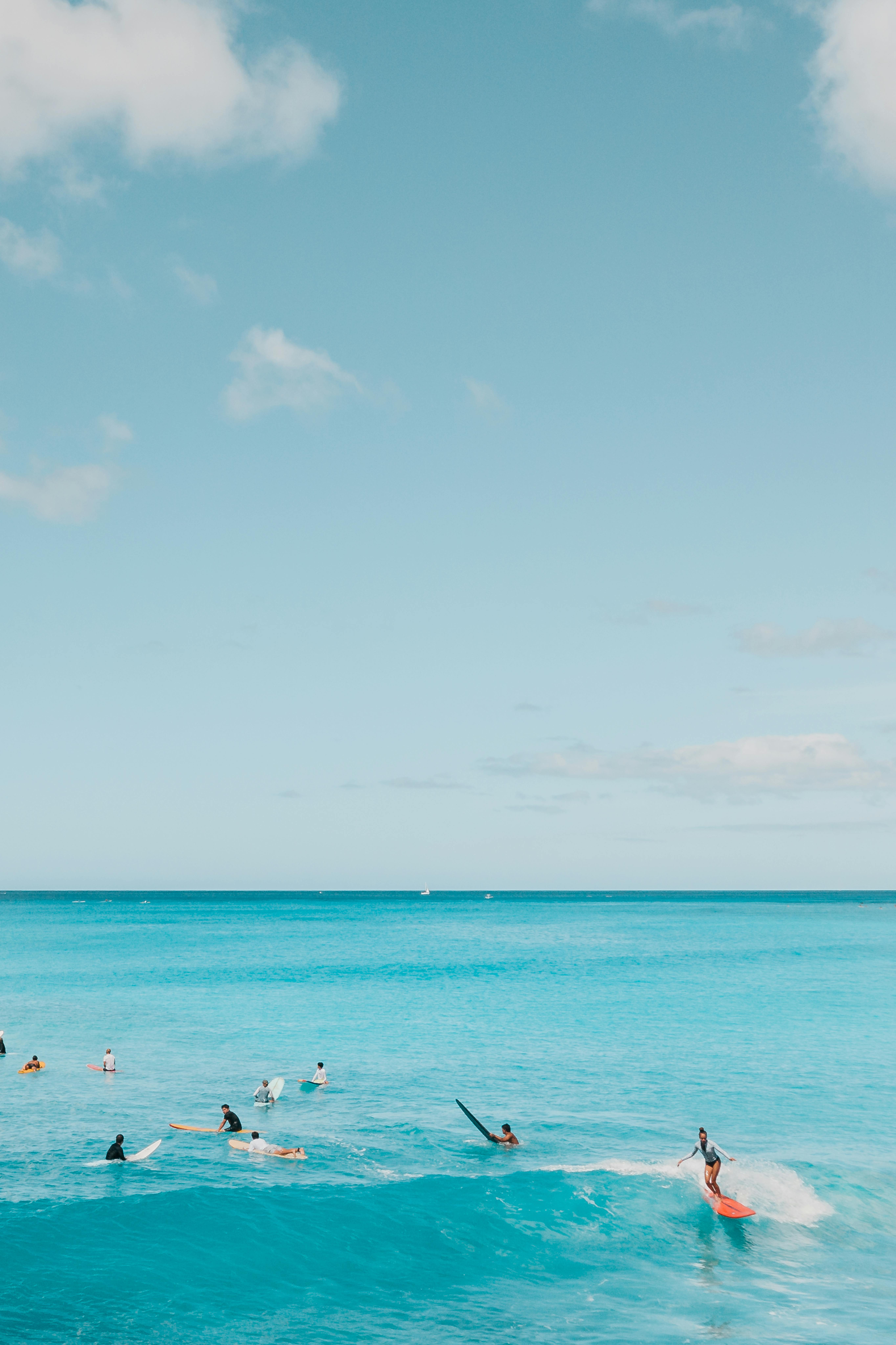 A group of surfers ride the turquoise waves under a clear blue sky, capturing the essence of beachside adventure.
