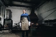 A Man Working with Irons Wearing an Apron