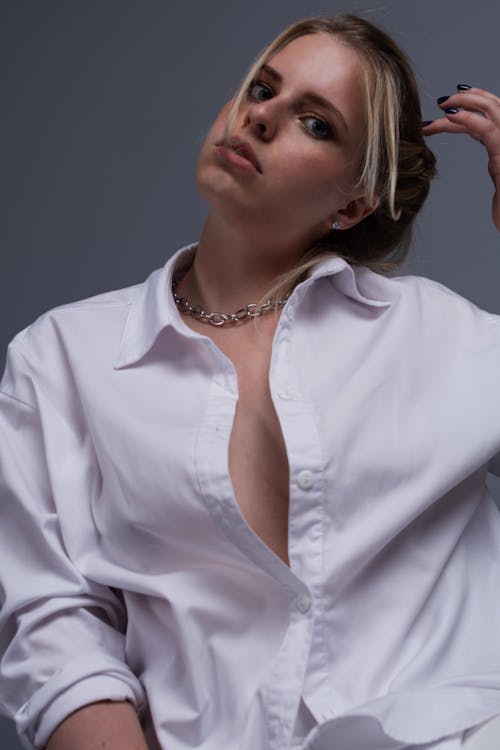 Free Woman in White Button Up Shirt Wearing Silver Necklace Stock Photo